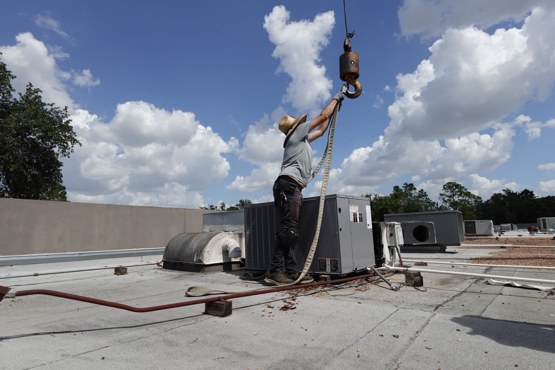 TruFlo technician on rooftop during commercial HVAC crane installation